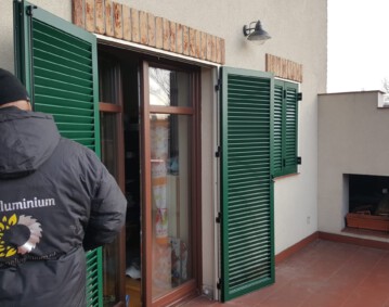 Okiennice aluminiowe zielone z ramą pracownik montuje